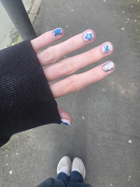 Blue hand-painted detail on a natural nail set